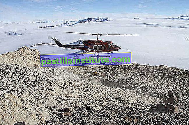 Алпинист прикачва товарна мрежа към хеликоптер, за да транспортира блок от изкопаеми скали от място за разкопки в планината.  Къркпатрик, Антарктида, по време на австралийското (южно полукълбо) лято 2010–11.